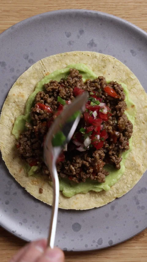 Adding Fresh Tomato Salsa to Tortilla with Ground Beef Vertical Close Up Vidéo 336577383