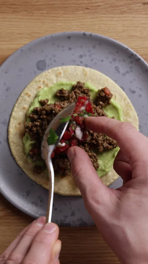 Adding Fresh Tomato Salsa to Tortilla with Guacamole and Ground Beef Vertical Vidéo 336577494