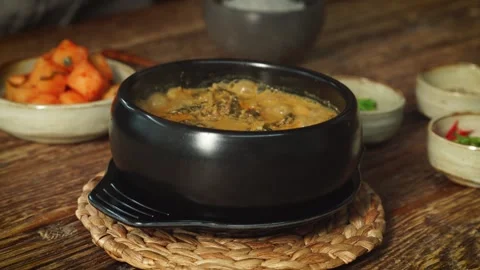 Adding Fresh Vegetables to Boiling Korean Soybean Paste Stew Stock Footage 335614188