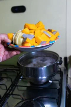 Adding fresh vegetables to a pot of soup Stock Photos
