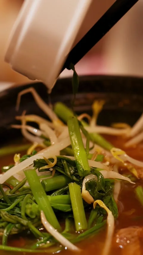Adding Fresh Vegetables to Thai Beef Hot Pot Soup With Chopsticks Video stock 346580247