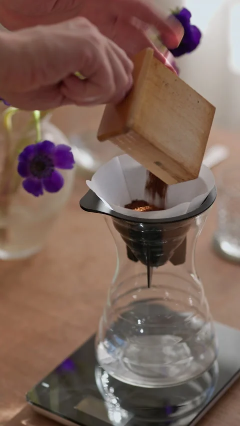 Adding freshly ground coffee in a v60 filter before brewing. Stock Footage 237921972