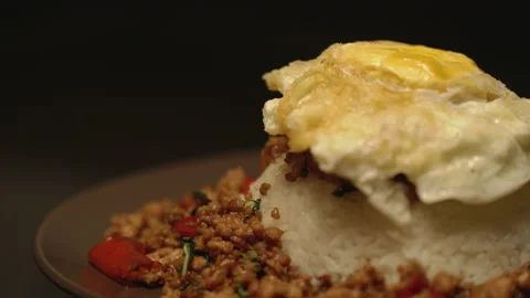 Adding fried egg on Pad Kaprao close up shot Stock Footage 150475098