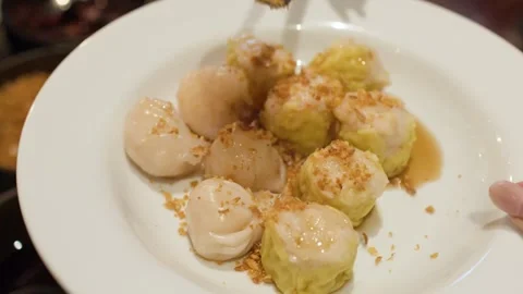 Adding Fried Garlic Topping to Fresh Steamed Shumai and Dumplings Stock Footage 333301249