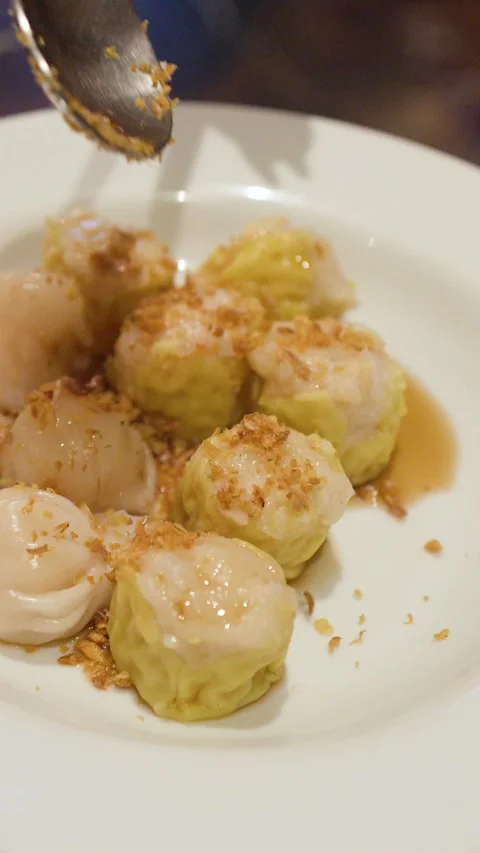 Adding Fried Garlic Toppings to Fresh Steamed Dim Sum Dumplings Stock Footage 333658812