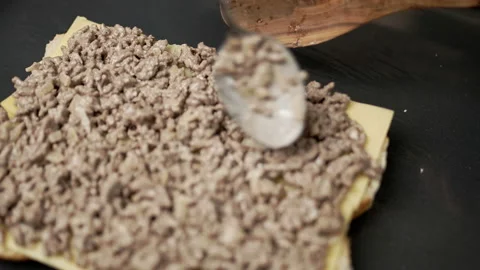 Adding fried ground beef on bread rolls in slow motion. Stock Footage 135463603
