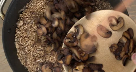Adding fried mushrooms to the pilau rice dish. Stock Footage 279174483