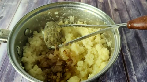 Adding fried onions to a pot with mashed boiled potatoes Stock Footage 232219452