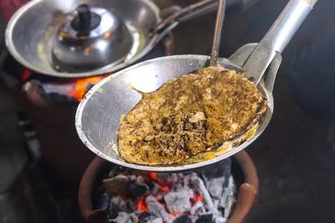 Adding Fried Shallot and Spiced Coconut Flakes Topping on Kerak Telor Omelett Foto stock