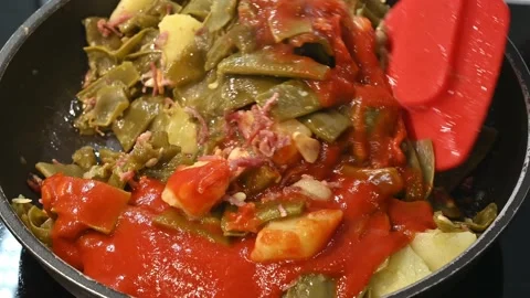 Adding fried tomato to finish the stew Stock Footage 219875668