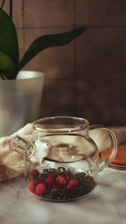 Adding Frozen Cranberries to Glass Teapot with Loose Tea Stock Footage 344042090