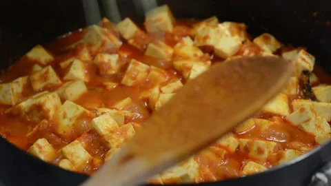 Adding Frozen Peas to the Curry Stock Footage 136059152