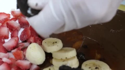 Adding Fruit and Cookie Toppings to a Fresh Dessert Crepe Stock-Footage 345653481