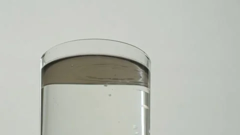 Adding fruit dye to a glass of water. Vídeos de archivo 137735405