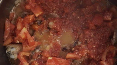 Adding garlic and chili to braised chicken overhead Stock Footage 121118592