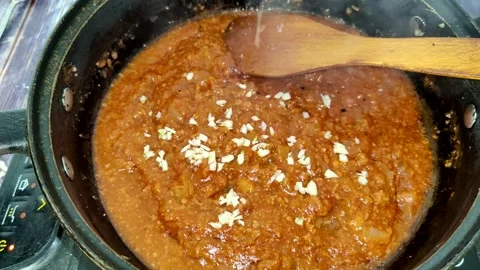 Adding garlic in tomato sauce with meat Stock Footage 227722745