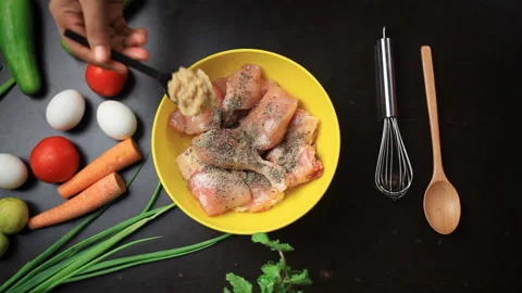 Adding ginger garlic paste to chicken pieces in a bowl, spices, black Video stock 165028036