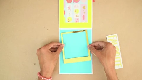 Adding golden frame and cutouts to scrapbook card design, shot from Stock Footage 289367638