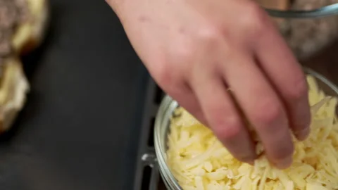 Adding grated cheese on bread rolls in slow motion. Stock Footage 135464085