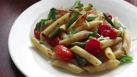 Adding grated cheese on hot penne pasta close view Vidéo 120058236