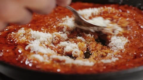 Adding grated cheese Parmesan to tomato sauce close-up. Cooking classic homemade Video stock 256678876