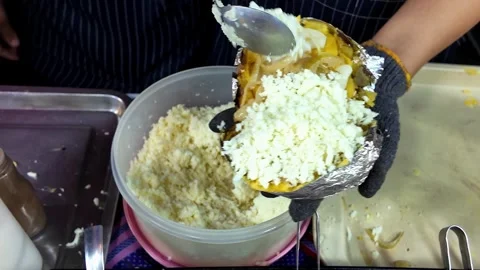 Adding Grated Cheese to Stuffed Baked Potato at Street Food Stall Stock Footage 337421368