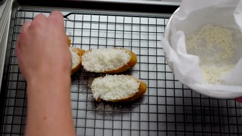Adding Grated Parmesan Cheese On Pieces Of Bread Stock Footage 139232622