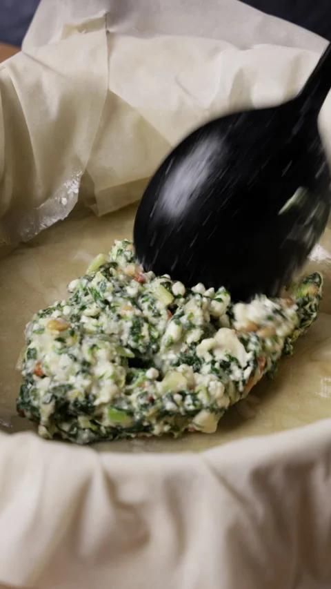 Adding Greek Spinach Feta Pie Filling To Phyllo Dough Pan Vertical Stock Footage 337289685