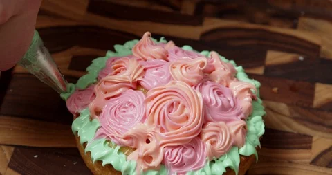 Adding green frosting to a cupcake Stock Footage 117019594