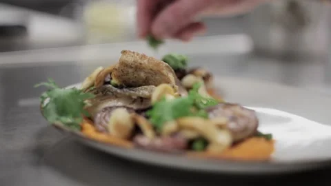 Adding green leaves into a dish containing meat and vegetables Stock-Footage 307340068