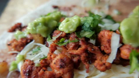 Adding green sauce on top of spicy meat, refried beans and cheese Stock Footage 147717334