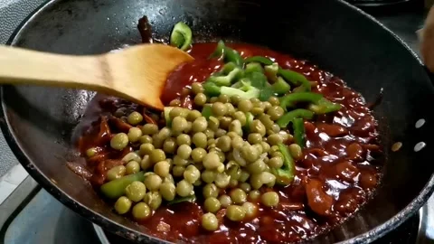 Adding Greenpeas and Bellpepper on a Sauce Stock Footage 149406092