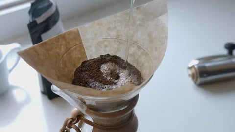 Adding Ground Coffee and Water to Chemex Pour Over Stock Footage 90985423