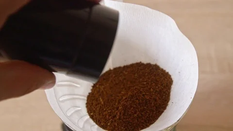 Adding ground coffee into paper filter for hand brew Stock Footage 120995269