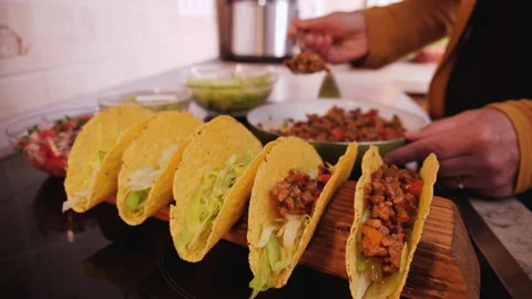 Adding the ground meat and vegetables filling to a taco - slow motion Stock-Footage 131929917