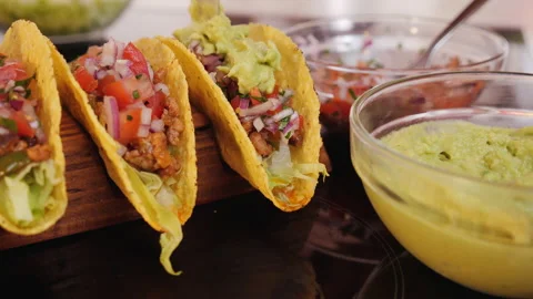 Adding the guacamole to tacos - static camera Stock Footage 140114725