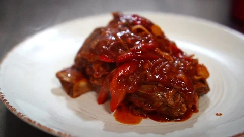 Adding healthy greens on top of delicious hot saucy pork vegetable ragout on Stock Footage 106979809