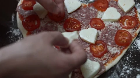 Adding heart shaped mozzarella to pizza on the baking tray. Preparing heart Stock Footage 146660206