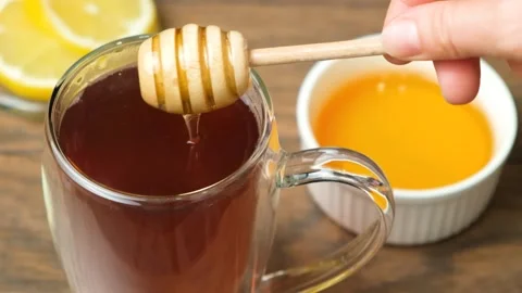 Adding honey to black tea, making vitamin healthy tea. Stock Footage 255829599