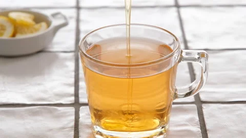 Adding honey in a cup of in a cup of hot sage tea Stock Footage 205072610