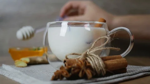 Adding honey to the cup glass cup of traditional indian masala chai tea. Indi Stock-Footage 121583347