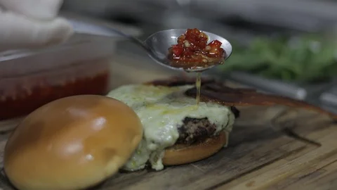 Adding Honey a Red Pepper Sauce in Cheeseburger made with Gorgonzola Cheese Stock Footage 129036211