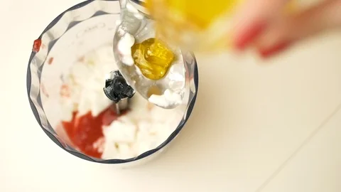 Adding honey to spoon with blurred blender bowl Stockbeeldmateriaal 124961236