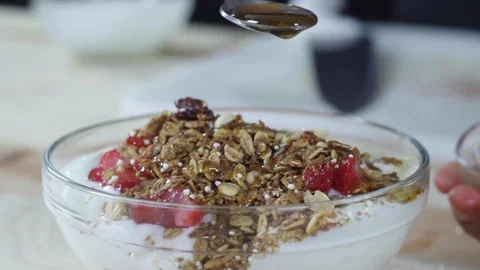 Adding honey to yogurt with granola Stock Footage 130062895