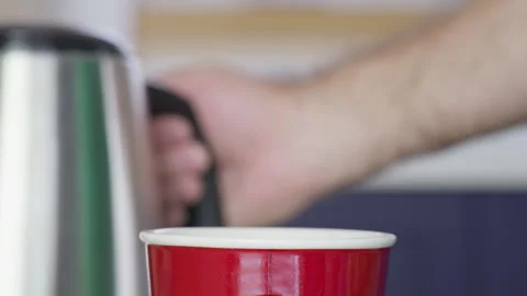 Adding hot water in red cup in kitchen side view Vídeo Stock 258082098