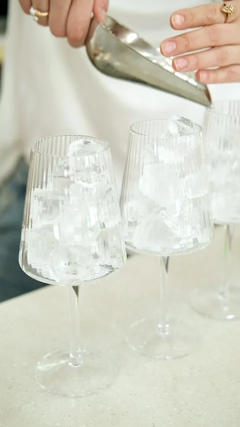Adding ice cubes in empty glass. Making a fresh drink on the counter. Vídeos de archivo 307273470