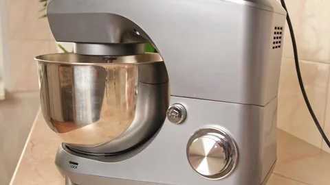 Adding ingredients to metal bowl of planetary mixer and mixing. Preparation of Stock Footage 244720264