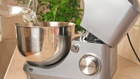 Adding ingredients to metal bowl of planetary mixer and mixing. Preparation of Stock Footage 244720302