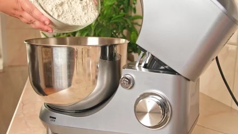 Adding ingredients to metal bowl of planetary mixer and mixing. Preparation of Stock Footage 244720700