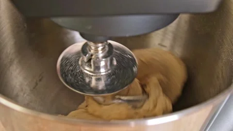 Adding ingredients to metal bowl of planetary mixer and mixing. Preparation of Stock Footage 244804319